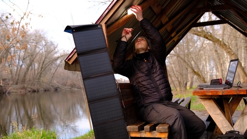 Man plugging a light into solar panels