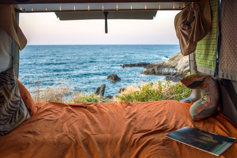 beautiful mediterranean view from a cozy bohemian camper van interior.